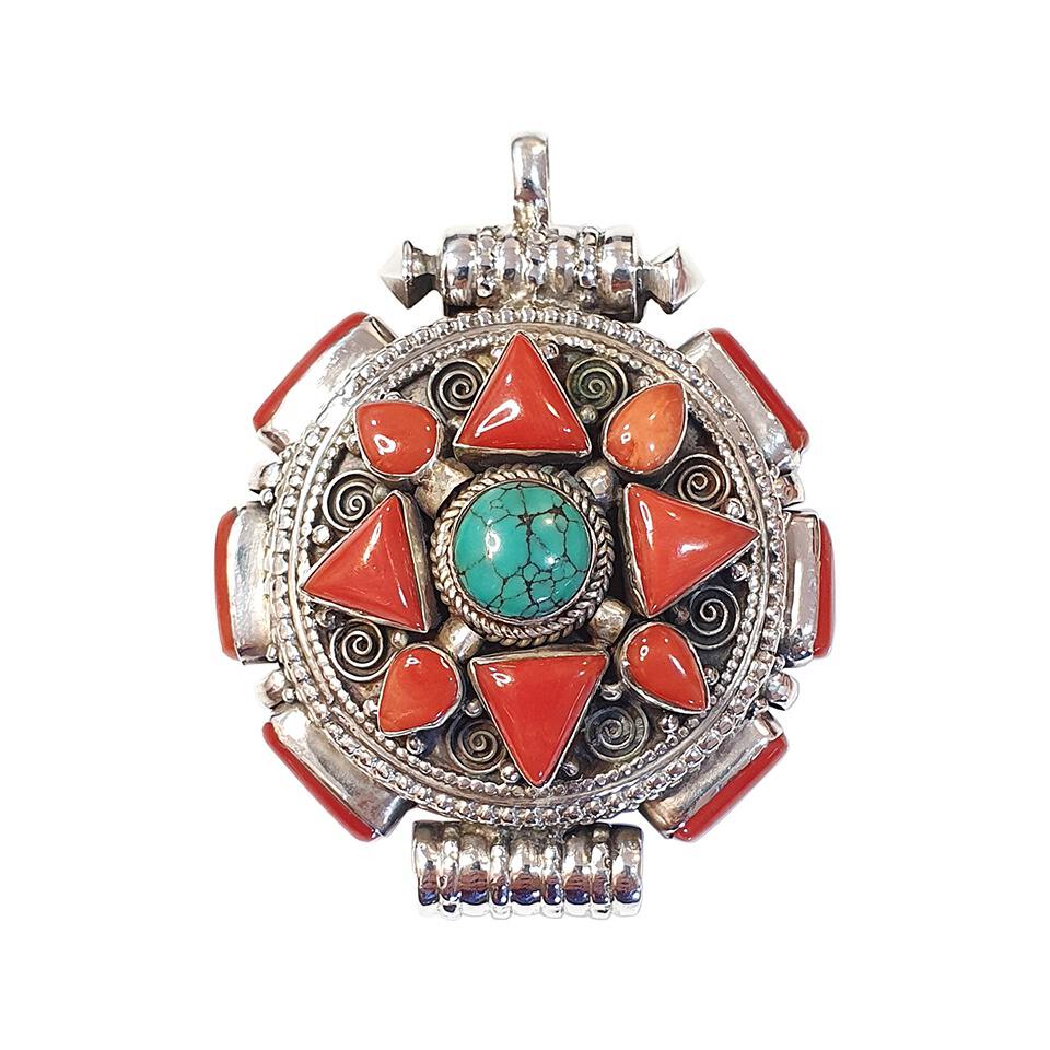 Tibetan round pendant with stabilized turquoise center and coral triangle inlays