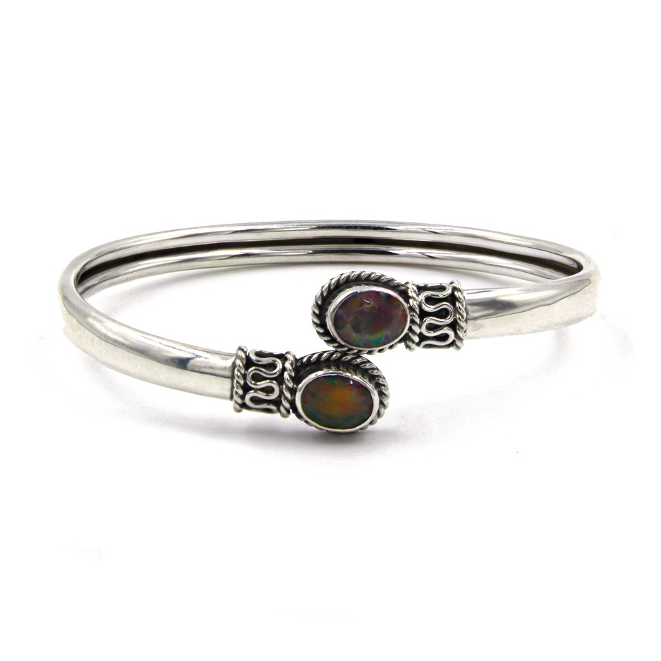 Sterling silver open bangle with dual oval fire opal gemstones and decorative accents
