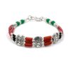 Handmade Tibetan silver bracelet with coral tubes and green beads.